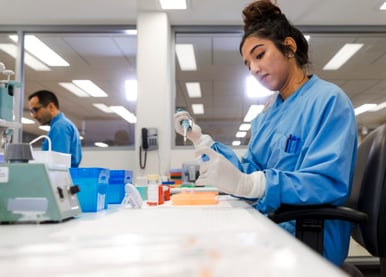 Woman in a lab using a pipette